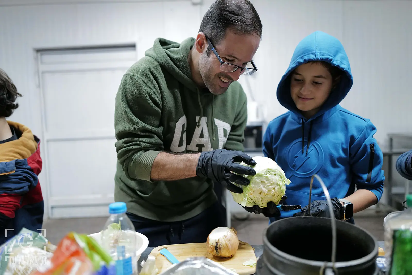אבא ובן צוחקים ומכינים יחד ירקות לסיר הפויקה